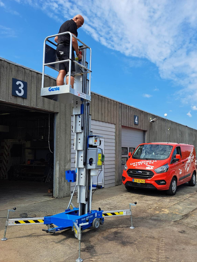 Liftservice søjlelift arbejder i lagerbygning